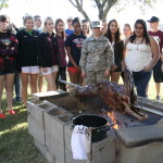 Students observing goat cooking