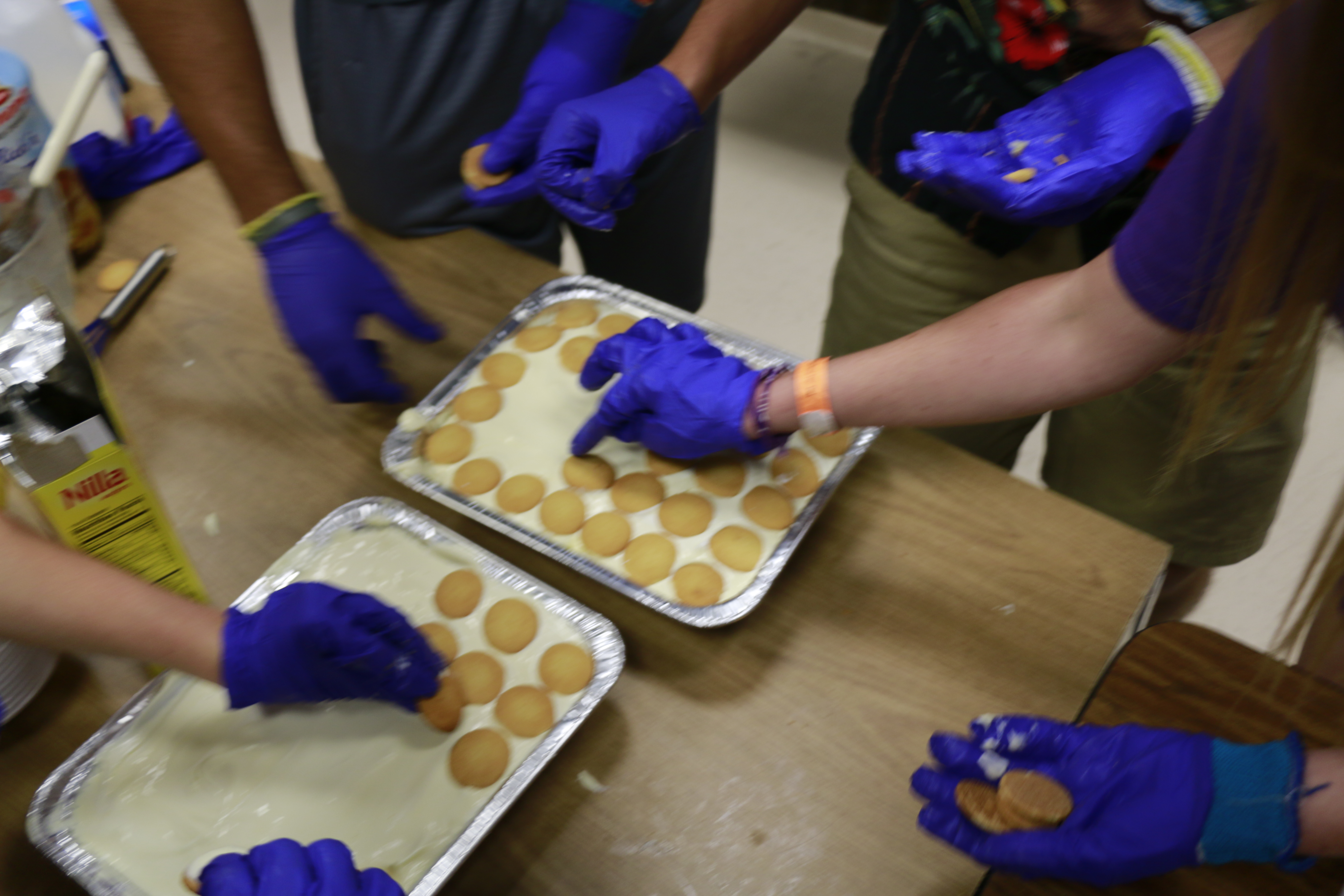 Students placing vanilla wafers on the banana pudding