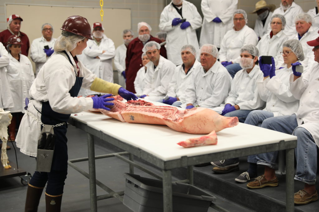 McKensie Harris breaking down a side of pork.