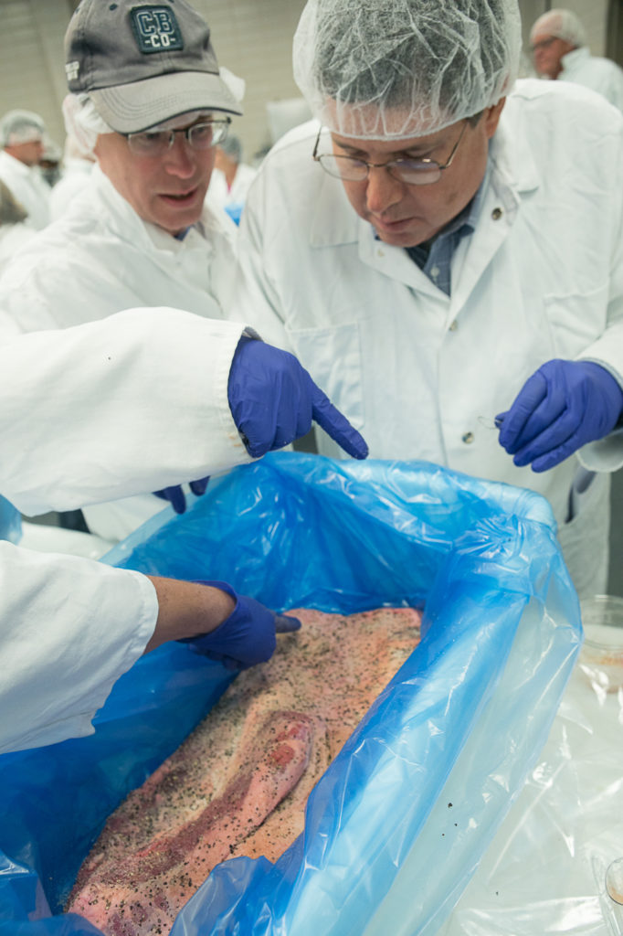 Participants spicing up a brisket!