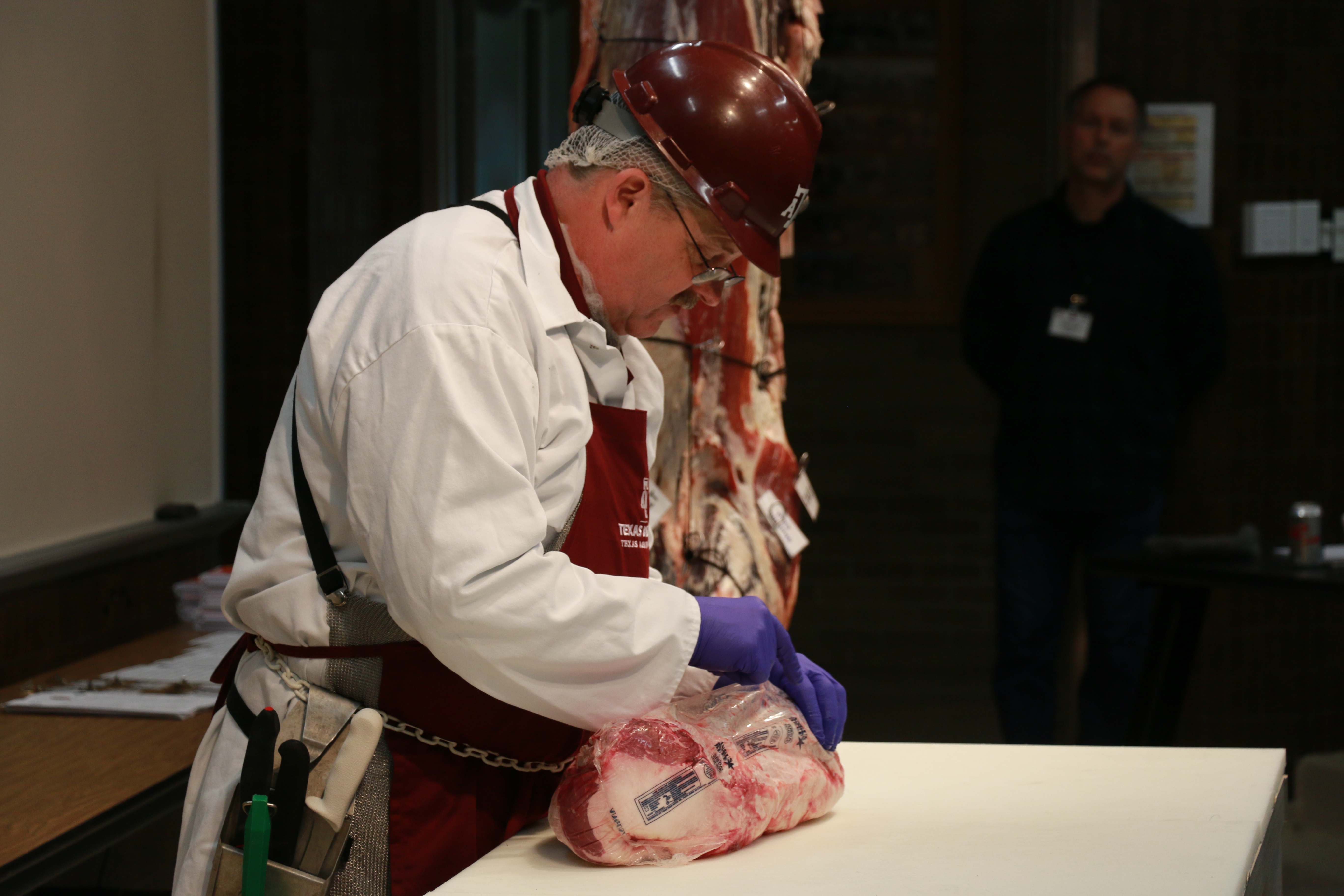 Davey Griffin removing the package from a beef brisket