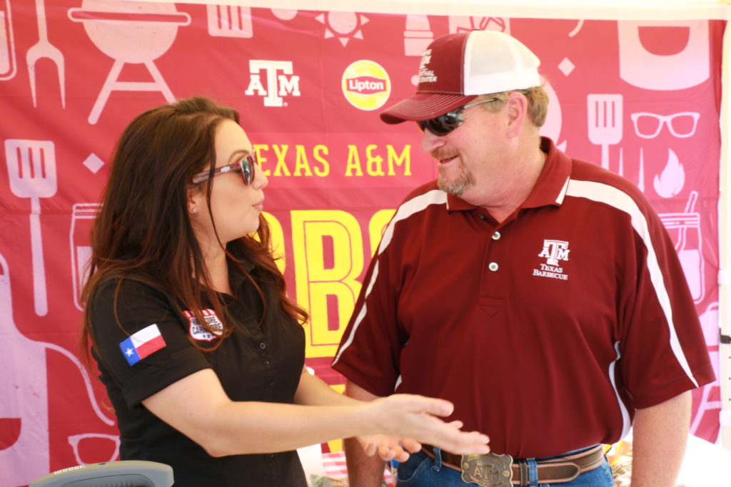 Jess Pryles visiting with Ray Riley at the Lipton Tea/Texas A&M BBQ Genius event