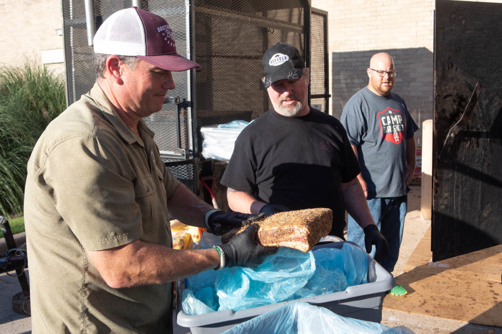 John Brotherton, Brotherton's Black Iron Barbecue, and Russell Roegels, Roegels Barbecue putting beef ribs on to cook (photo by Kelly Yandell)