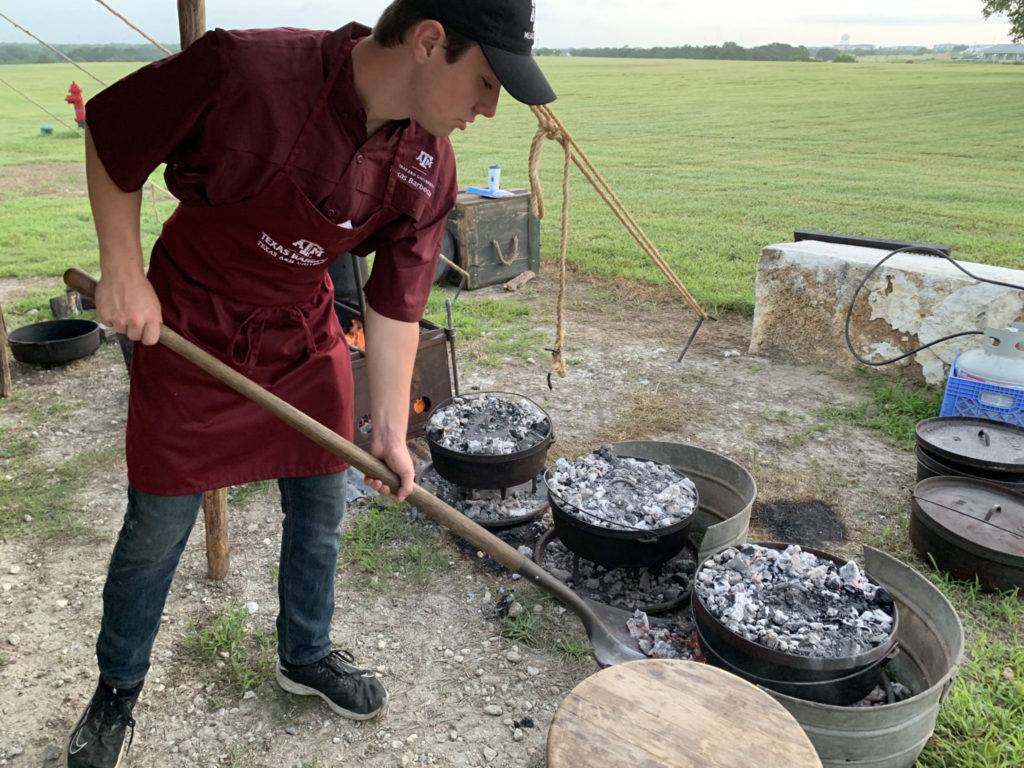 Jackson Larriviere tending to Dutch ovens at Camp Brisket